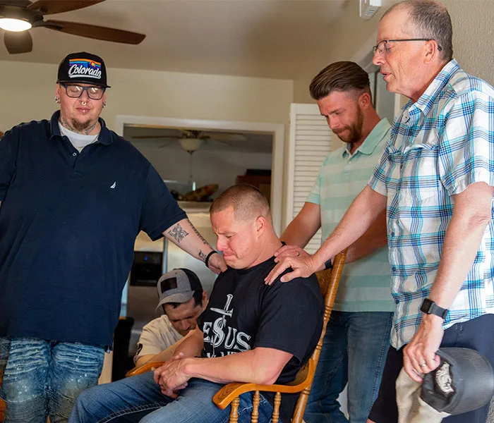 Harvest Farm program participants and staff praying together.