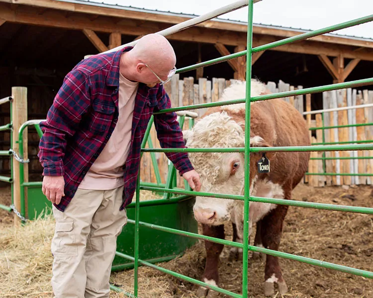 Program participant, Ron, and cow from Harvest Farm