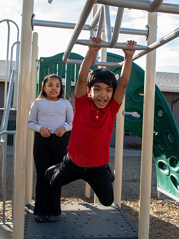 Amarissa and Danbi playing on the monkey bars.