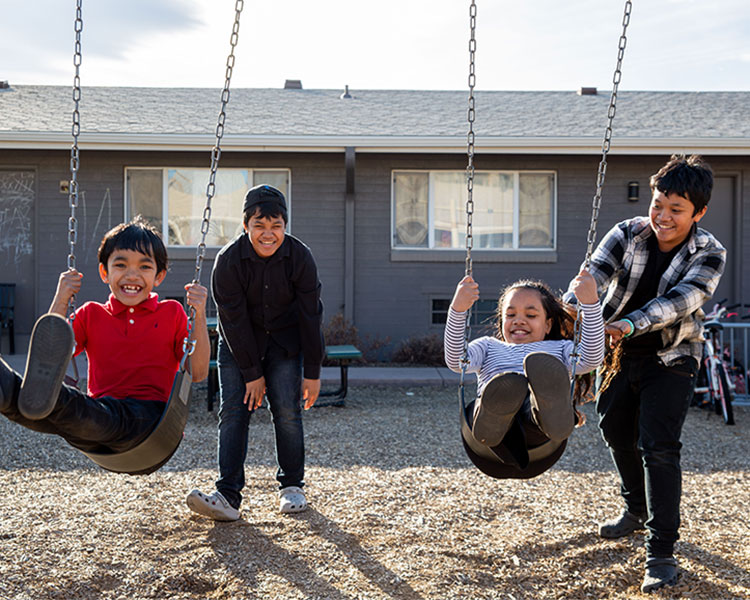 Danbi, Danley, Amarissa, and Daniel playing on the swing set.